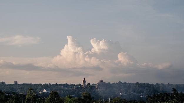 Atmosfera panorama cumulus białe chmury nad buddyjską świątynią statua dramatyczne niebo zachód słońca medytacja tło