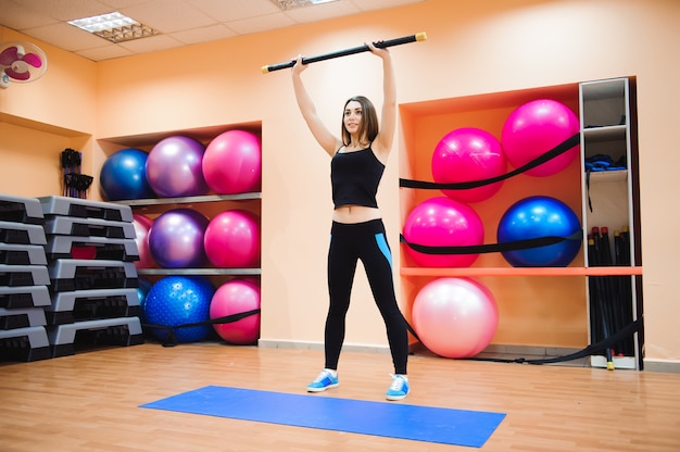 Atrakcyjna atlety młoda kobieta robi ćwiczeniu przy gym.