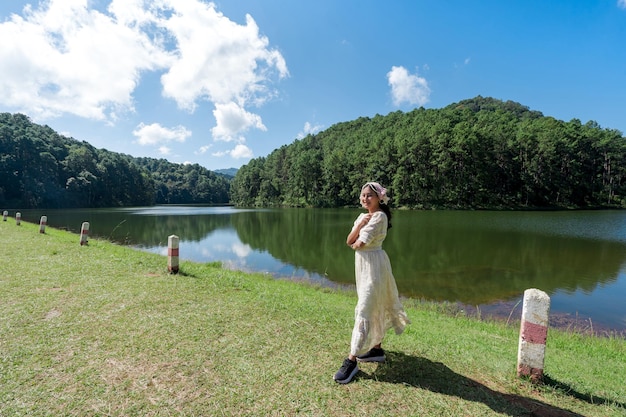 Atrakcyjna Azjatycka Kobieta W Białej Sukni Stojącej Na ścieżce Spacerowej Tamy W Pang Ung Z Widokiem Na Jezioro I Góry W Mae Hong Son, Tajlandia