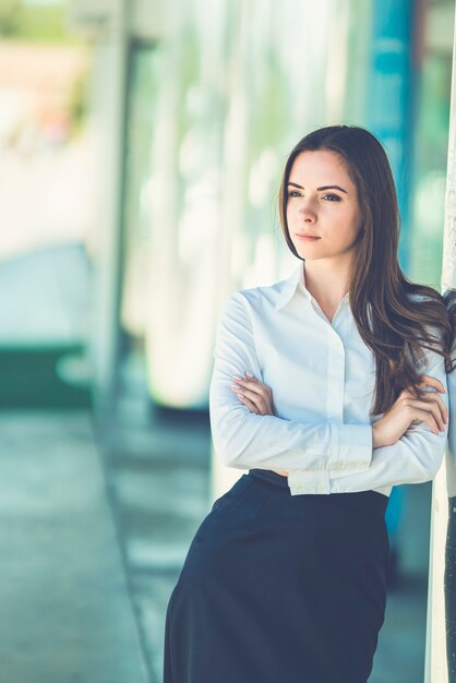 Atrakcyjna bizneswoman stoi w pobliżu budynku