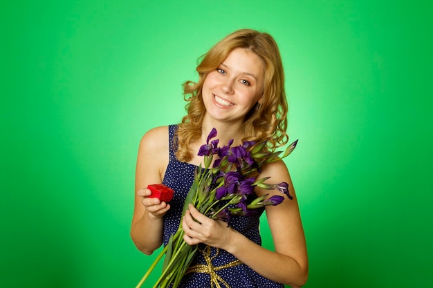 Atrakcyjna dziewczyna trzyma kwiaty i pudełko na prezent