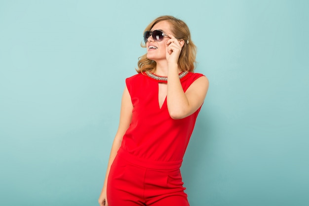 Zdjęcie atrakcyjna kobieta w czerwonych kombinezonach i okularach przeciwsłonecznych