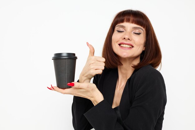 Atrakcyjna kobieta w garniturze, szklanka kawy, pozowanie na białym tle