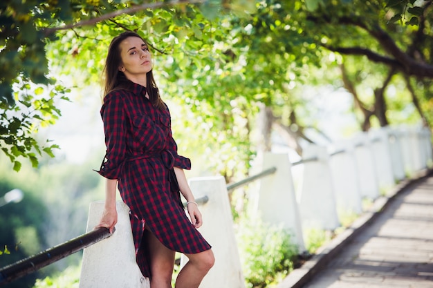 Atrakcyjna młoda kobieta pokazuje nogę podczas gdy chodzący w parku