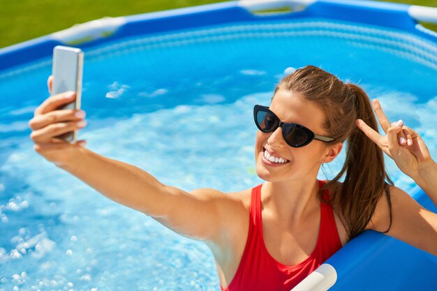 atrakcyjna młoda kobieta relaksuje się na basenie na podwórku