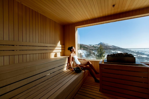 Atrakcyjna młoda kobieta relaksuje się w saunie