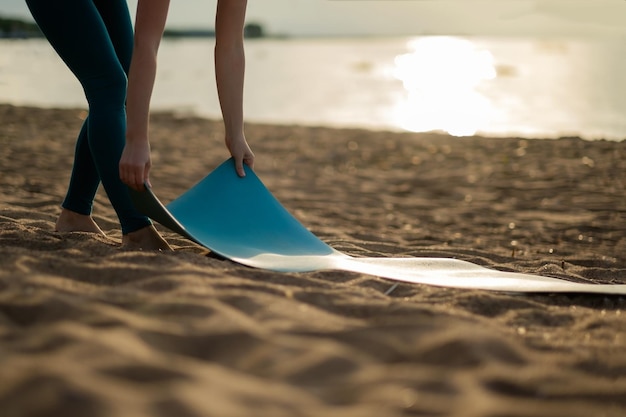 Atrakcyjna Młoda Kobieta Składa Zieloną Matę Do Jogi Lub Fitness Po Treningu Na Plaży