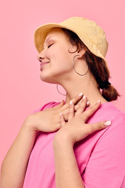 Atrakcyjna młoda kobieta w beżowej panama różowy tshirt gesty dłoni styl życia