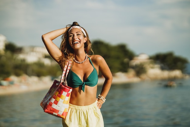 Atrakcyjna młoda kobieta w bikini bawi się na plaży i spędza wakacje.