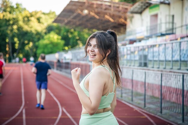 Atrakcyjna młoda kobieta w sportowej joggingu na stadionie