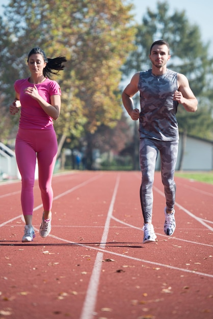 Atrakcyjna para sprint na bieżni w okolicy parku miejskiego Trening i ćwiczenia wytrzymałościowe Fitness zdrowy styl życia koncepcja na świeżym powietrzu