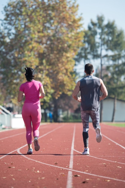 Atrakcyjna para sprint na bieżni w okolicy parku miejskiego Trening i ćwiczenia wytrzymałościowe Fitness zdrowy styl życia koncepcja na świeżym powietrzu