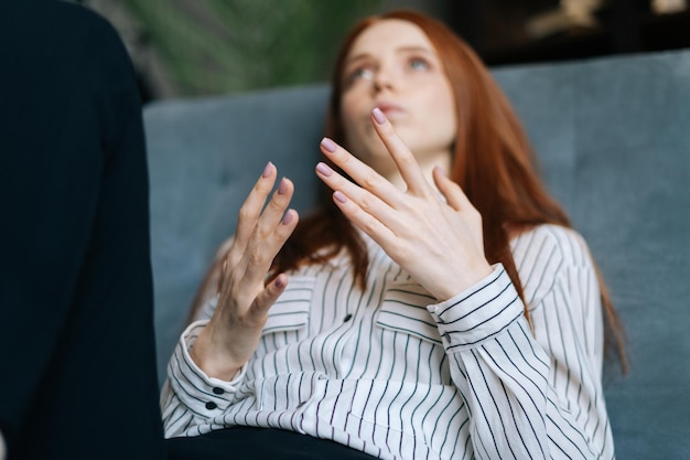 Atrakcyjna rudowłosa młoda pacjentka leżąca na wygodnym fotelu i opowiadająca o swoich problemach psychoterapeuty. Przygnębiona pani rozmawiająca z lekarzem podczas terapii doradczej.