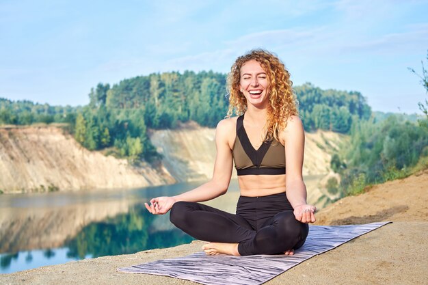 Atrakcyjna rudzielec kędzierzawa kobieta lub model ćwiczy joga outdoors