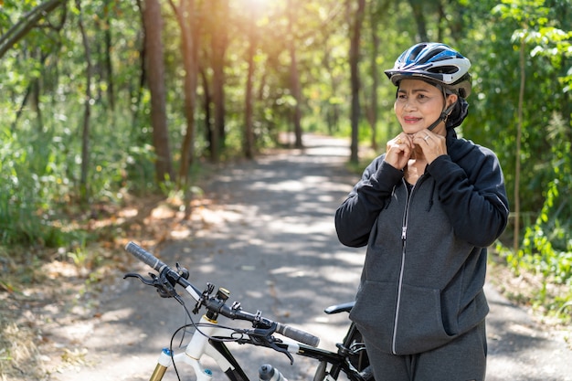 Atrakcyjna Starsza Azjatykcia Kobieta Z Bicyklem W Parku