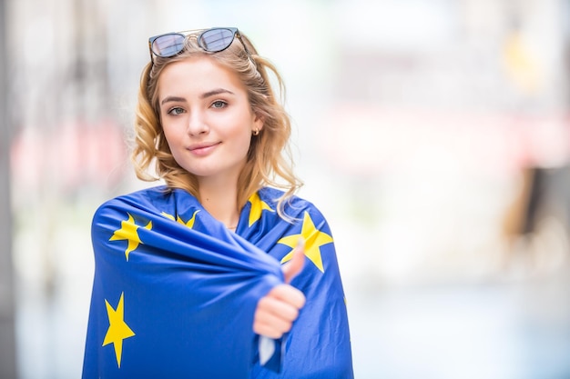 Zdjęcie atrakcyjna, szczęśliwa młoda dziewczyna z flagą unii europejskiej