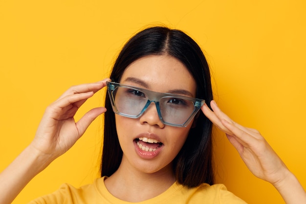 Atrakcyjne azjatyckie okulary kobiety pozują żółte tło