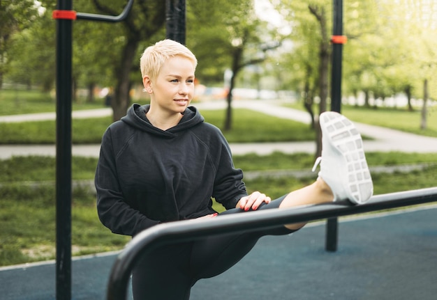 Atrakcyjne dopasowanie młoda kobieta w sporcie nosić rozciąganie na ulicy treningu. Zdrowy styl życia w mieście