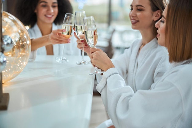 Atrakcyjne młode kobiety brzęczą kieliszkami do szampana przy barze!
