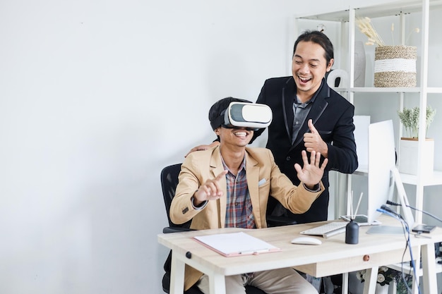 Atrakcyjni dwaj młodzi azjatyccy pracownicy przeprowadzający symulację przy użyciu okularów VR w biurze.