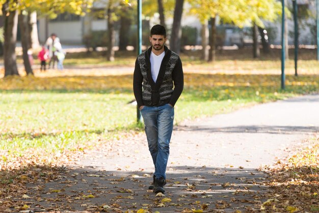 Atrakcyjny mężczyzna spacerujący w jesiennym lesie