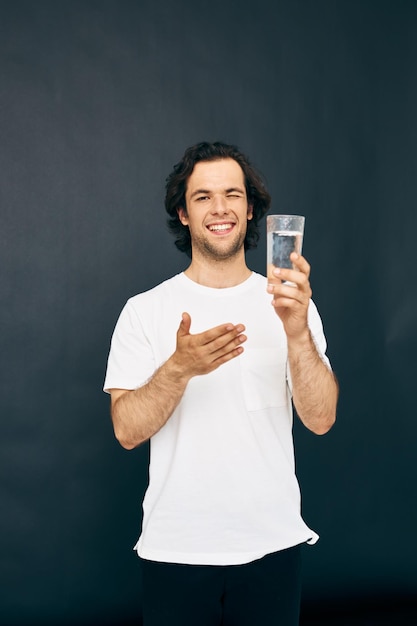 Zdjęcie atrakcyjny mężczyzna w białej koszulce szklanka wody styl życia niezmieniony