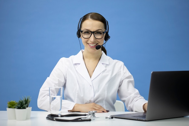 Atrakcyjny Seksowny Internetowy Konsultant Medyczny W Zestawie Słuchawkowym Patrzy Na Kamerę I Uśmiecha Się