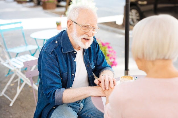 Atrakcyjny starszy mężczyzna siedzi z żoną i rozmawia