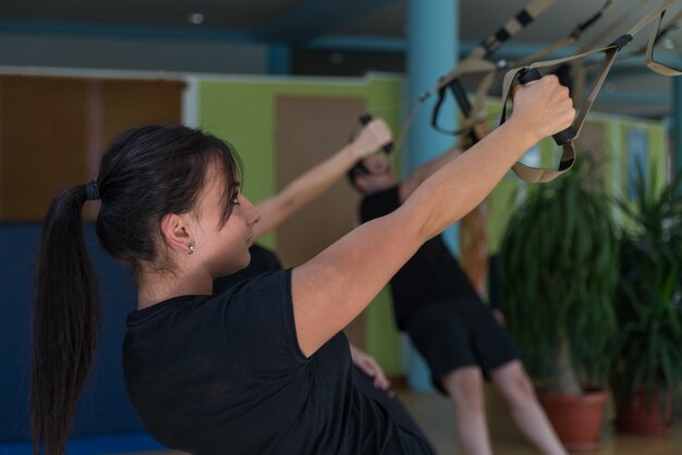 Atrakcyjny trening zespołowy z paskami Fitness Trx na siłowni