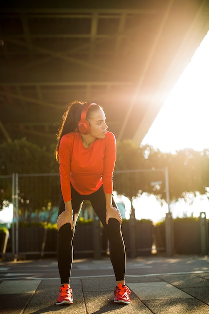 Zdjęcie atrakcyjny żeński biegacz bierze przerwę po jogging outdoors