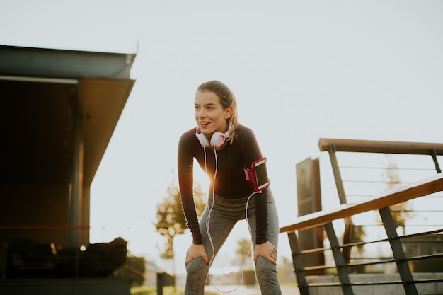 Zdjęcie atrakcyjny żeński biegacz bierze przerwę po jogging outdoors