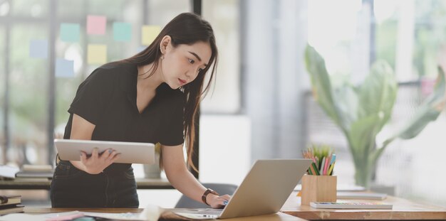 Atrakcyjny żeński freelancer pracuje nad projektem z laptopem