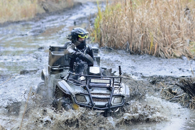 ATV i UTV w akcji na torze wodnym z rozbryzgami błota wodnego. Ekstremalna konkurencja. 4x4.