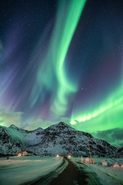 Aurora Borealis, Eksplozja Zorzy Polarnej Nad Górą śniegu I Drogą Na Zimę W Flakstad, Lofoty, Norwegia