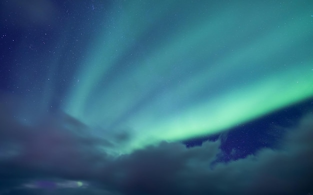 Aurora Borealis Wyspy Senja Norwegia Gwiazdy poruszające się chmury i zorza polarna Nocny krajobraz Naturalne tło Obraz z podróży