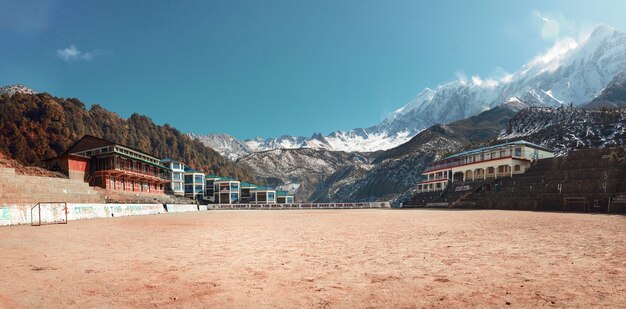 Autentyczna piaszczysta arena piłkarska otoczona ośnieżonymi górami Nepalu stonowana fotografia