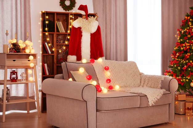 Autentyczny kostium Świętego Mikołaja wiszący w pokoju udekorowanym na Boże Narodzenie