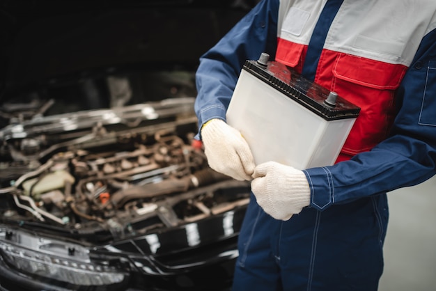 Auto Mechanic Ma Zamiar Wymienić Nową Baterię Dla Klientów, Którzy Korzystają Z Usługi Wymiany Baterii W Sklepie.