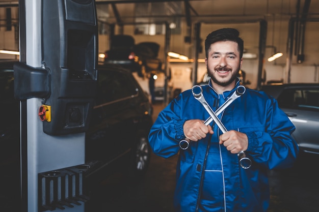 auto mechanik naprawiający samochody w garażu serwisowym