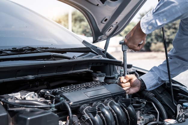 Auto mechanik ręce za pomocą klucza do naprawy silnika samochodowego