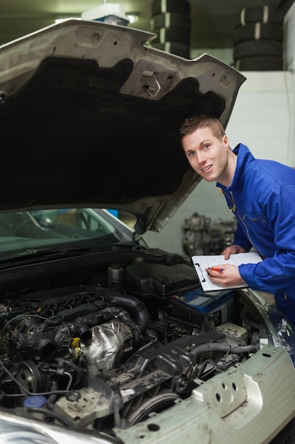 Auto mechanik ze schowka badając samochód