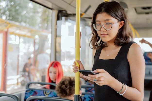 Autobus stoi na przystanku autobusowym w centrum kobieta w okularach jedzie transportem publicznym