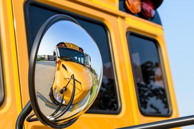 Autobus szkolny odbija się w lustrze.