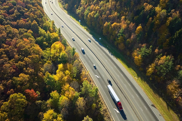 Autostrada I40 prowadząca do Asheville w Karolinie Północnej przez przełęcz Appalachów z żółtym lasem jesiennym i szybko poruszającymi się ciężarówkami i samochodami Koncepcja szybkiego transportu międzystanowego