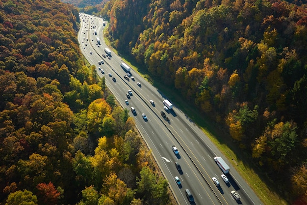 Autostrada I40 w Północnej Karolinie prowadząca do Asheville przez Appalachy w złotej jesieni z szybko poruszającymi się ciężarówkami i samochodami Koncepcja transportu międzystanowego