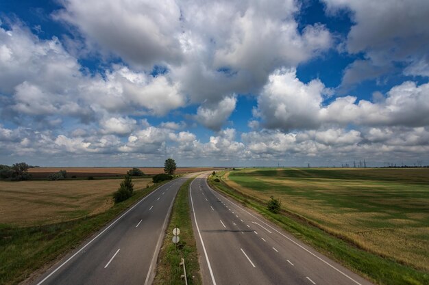 Autostrada między polami pod pięknym niebem z białymi chmurami