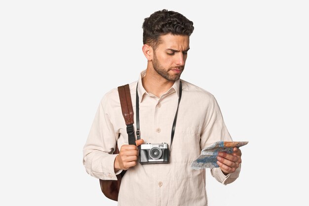 Awanturniczy młody człowiek z rocznika kamery mapą i plecakiem