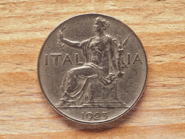 Awers monety 1 lira przedstawiający siedzącą kobietę z reprezentacją wawrzynu
