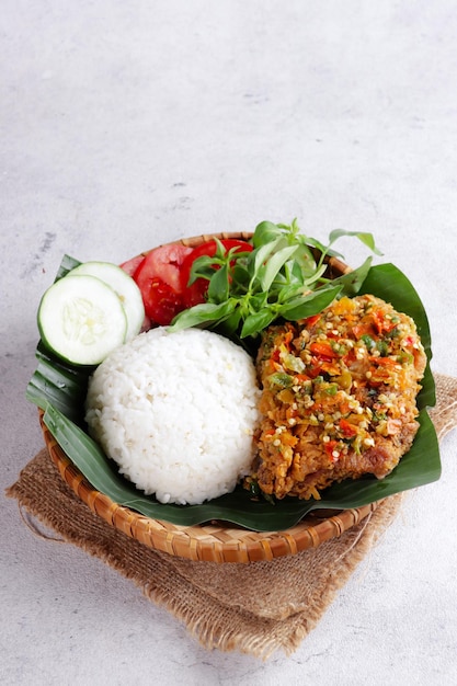 Zdjęcie ayam geprek to popularne jedzenie uliczne w indonezji z chrupiącego kurczaka rozgniecione w sambal bawang