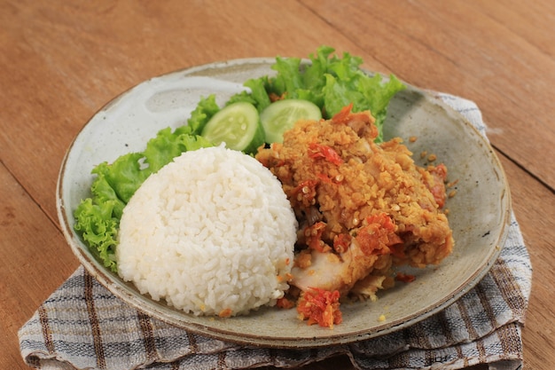 Ayam Geprek to popularne jedzenie uliczne w Indonezji. Z Chrupiącego Kurczaka Rozgniecionego w Sambal Bawang (sos czosnkowy chili). Podawany z Ryżem i Warzywami